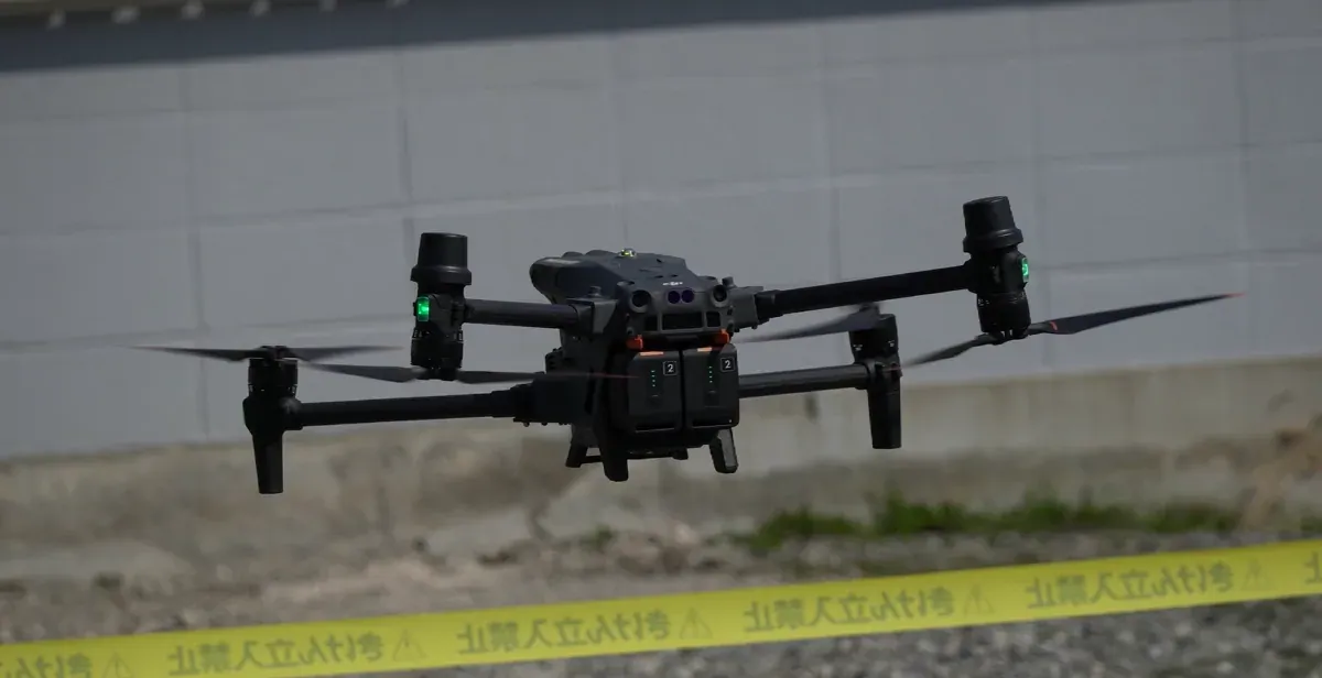 立入規制された現場の上空を飛行する産業用ドローン